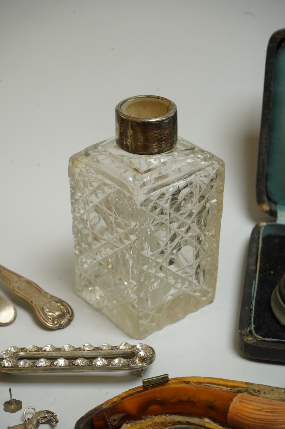 A small collection of silver and white metal charms, including Holy Bible, Penny Farthing, hedgehog and squirrel, together with a silver compact and ashtray, a silver and paste brooch, nut vesta, pipe, etc.